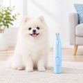 White pet grooming clipper beside a fluffy dog, shown with generous space around the products